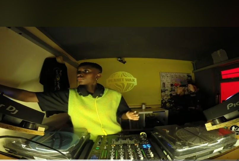 A DJ playing music in a room for a YouTube video 